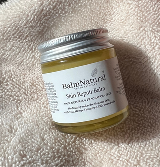 A jar of Skin Repair Balm on a cream towel. 100% natural ingredients to hydrate dry flaky itchy crusty skin. Leaving skin soft and hydrated.